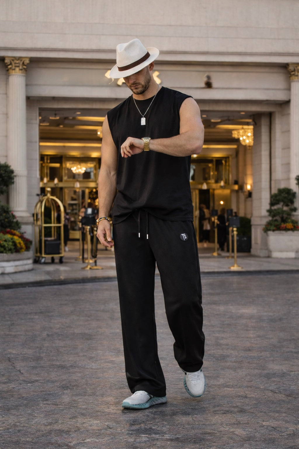 Modern black wide leg sweatpants styled with a sleeveless top and sneakers for a refined streetwear look