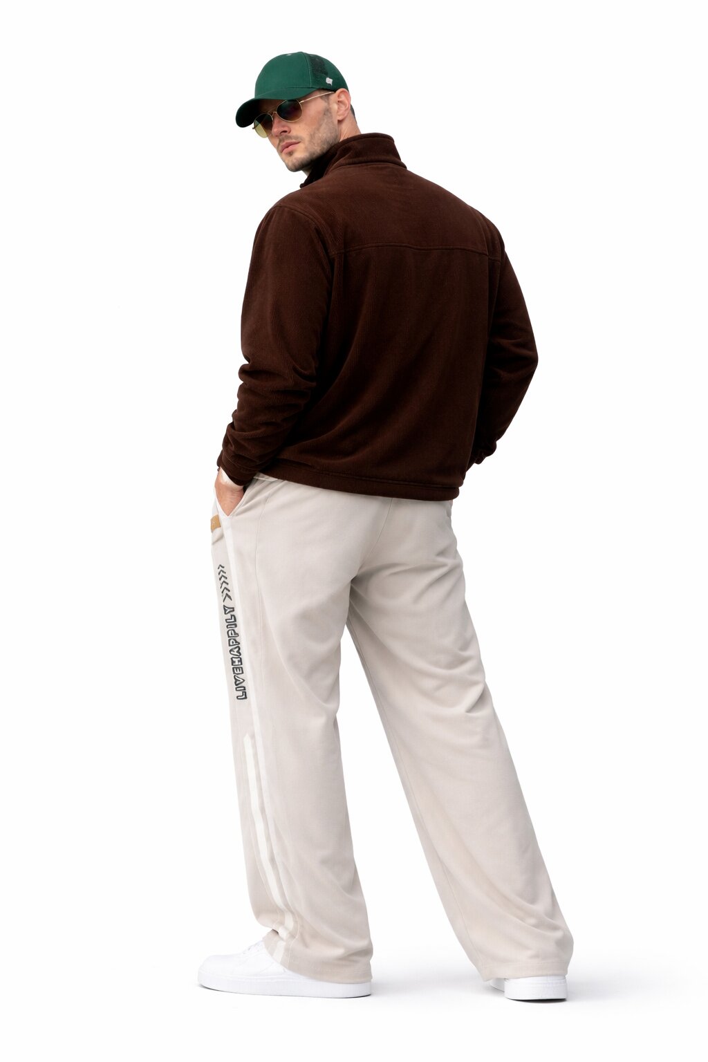 Men’s twilight taupe wide leg track pants with side stripe detail styled with brown quarter zip, green cap, and white sneakers back view