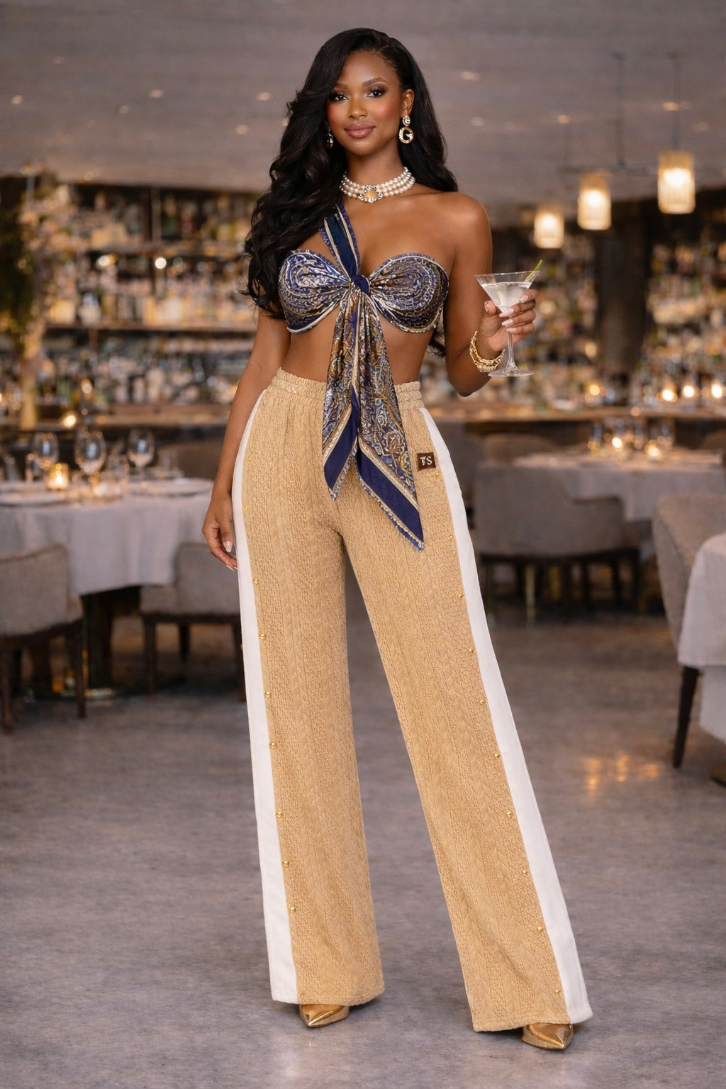 Women’s camel beige waffle knit wide leg pants with side stripe detail styled with printed scarf top and gold heels front view