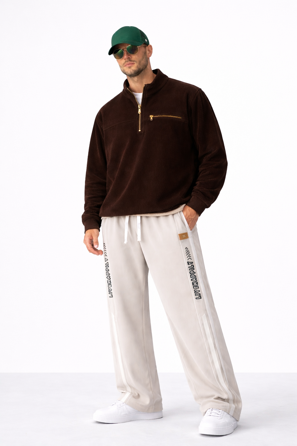 Relaxed fit beige track pants styled with a brown quarter zip and clean white sneakers for a modern casual look